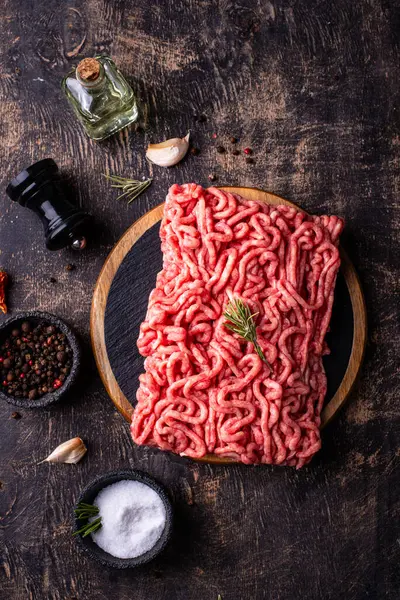 Koyu arkaplanda baharatlı çiğ et.