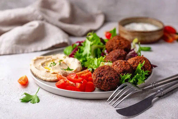 Humus, falafel ve sebzeli sağlıklı vejetaryen salatası.