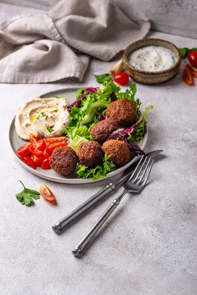 Humus, falafel ve sebzeli sağlıklı vejetaryen salatası.