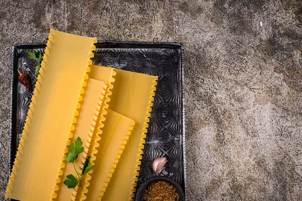 Koyu arkaplanda pişmemiş çiğ lazanya.