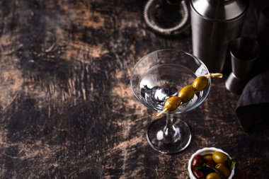 Zeytin ve barmen aletli geleneksel martini kokteyli.