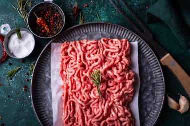 Koyu arkaplanda baharatlı çiğ et.