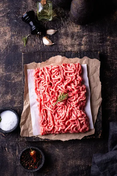 Koyu arkaplanda baharatlı çiğ et.