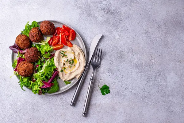 Humus, falafel ve sebzeli sağlıklı vejetaryen salatası.