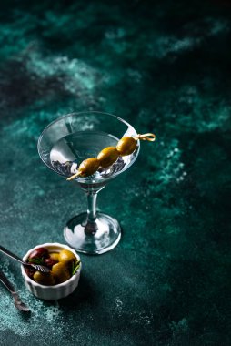 Zeytin ve barmen aletli geleneksel martini kokteyli.
