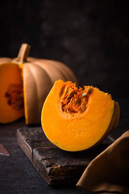 Koyu arka planda çiğ balkabağı, karanlık ruh hali tarzı.