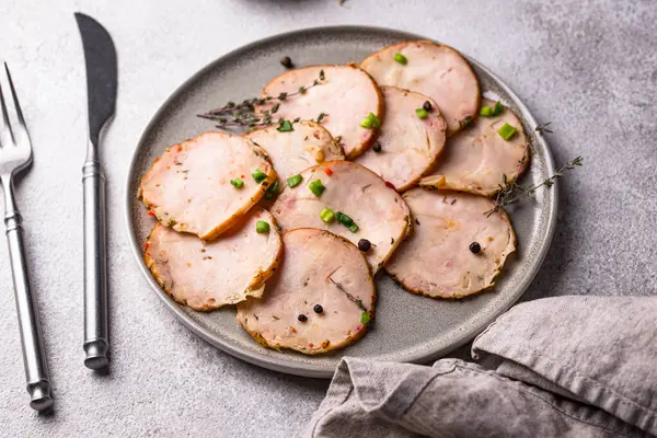 Tabağında bitkiler olan dilimlenmiş tavuk sosisi.