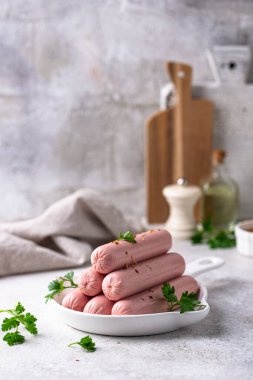 Arka planda baharatlı haşlanmış domuz sosisi.