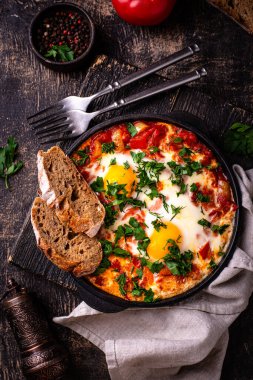 Yumurtalı Shakshuka, domates ve biberli. Geleneksel Yahudi kahvaltı yemeği