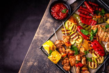 Çeşitli yaz ızgara bbq çeşitleri. Shashlik, ızgara sosis, sebze ve sos.
