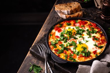 Yumurtalı Shakshuka, domates ve biberli. Geleneksel Yahudi kahvaltı yemeği