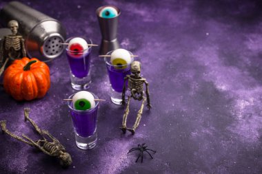 Cadılar Bayramı içkisi. Gözlerle süslenmiş mor shot kokteyli..