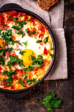 Yumurtalı Shakshuka, domates ve biberli. Geleneksel Yahudi kahvaltı yemeği