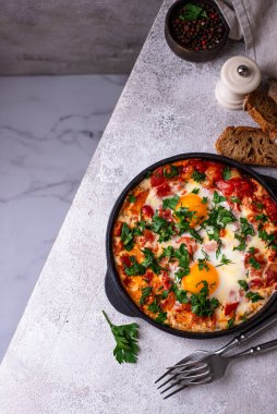 Yumurtalı Shakshuka, domates ve biberli. Geleneksel Yahudi kahvaltı yemeği