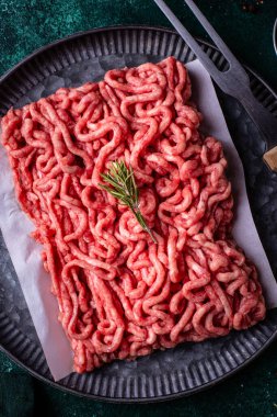 Koyu arkaplanda baharatlı çiğ et.