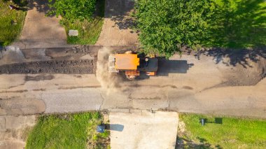 İnşaat aracı yeni asfalt tabakası için yol hazırlıyor