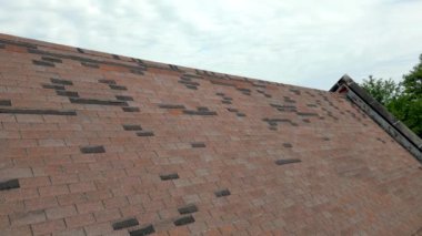 Tamire ihtiyacı olan çatı, fırtına hasarı yüzünden kayıp kiremitler.