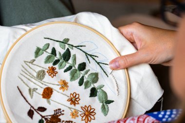 Kadın elleri iplik ve iğneyle nakış işliyor.