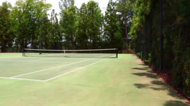 Ağ, çit vs. ile boş tenis kortu.