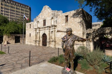 San Antonio, TX - 6 Nisan 2025: Alamo Plaza 'da Alamo Kilisesi' nde David Crockett 'in bronz heykeli.