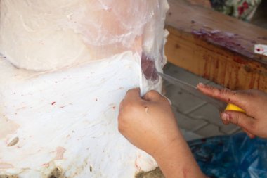 Adamlar kesme tahtasıyla bir parça et kesiyorlar..