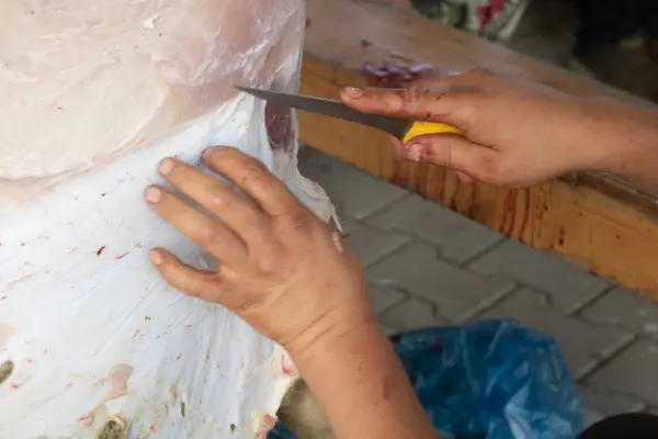 Adamlar kesme tahtasıyla bir parça et kesiyorlar..