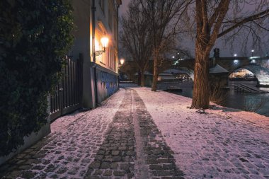 Snowy Streets of Prague with Illuminated Street Lights at Night clipart