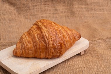 Tahta kesme tahtasındaki sade kruvasanlar beyaz mermer arka planda