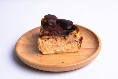 Bask peynirli keki ahşap tabakta beyaz arka planda yaktı.