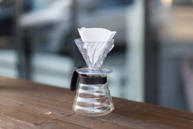 Bir hunide kahve yapmak. Funnel 'e kahve dök. Alternatif Yöntem. Koyu arkaplanı olan güzel bir masa. Kahve spesiyalitesini demleme süreci.