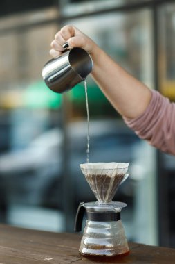 Bir hunide kahve yapmak. Funnel 'deki kahvenin üzerine dök. Alternatif Yöntem. Koyu arkaplanı olan güzel bir masa. Kahve spesiyalitesini demleme süreci. Kahve dökülüyor.