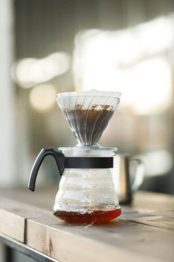 Bir hunide kahve yapmak. Funnel 'deki kahvenin üzerine dök. Alternatif Yöntem. Koyu arkaplanı olan güzel bir masa. Kahve spesiyalitesini demleme süreci. Kahve dökülüyor.
