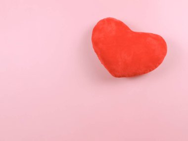 Pembe arka planda kırmızı kalp yastığının üstü ya da düzlüğü.