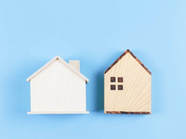 Mavi arka planda iki ahşap model evin üst ya da düz yatışı.