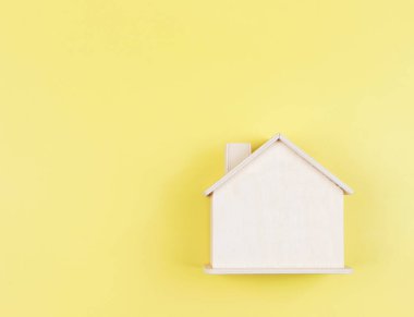 Top view or flat lay of wooden model house isolated on yellow background.