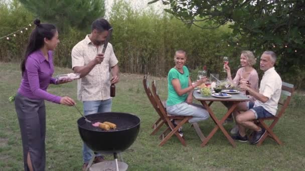 인종적으로 사람들 바베큐에서 옥수수와 고기를 요리하면서 행복하게 동작으로 웃는다 고품질 — 비디오