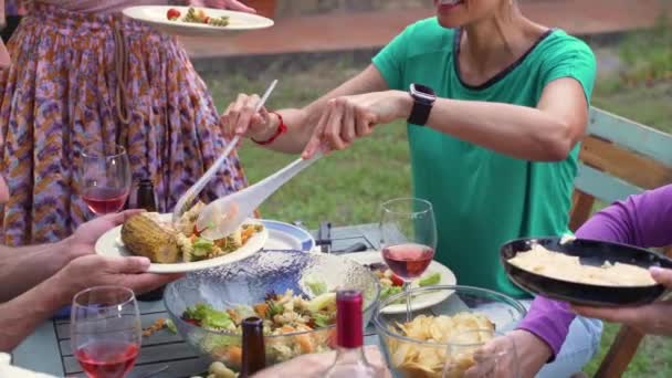 快乐的朋友们笑着围坐在桌旁 女人在家里的庭院里招待食物 快乐的概念 高质量的照片 — 图库视频影像
