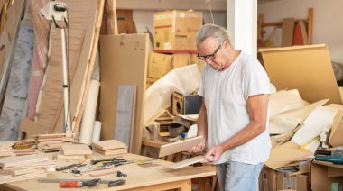 Marangoz atölyede ahşap mobilya afişi yapıyor. Yüksek kalite fotoğraf