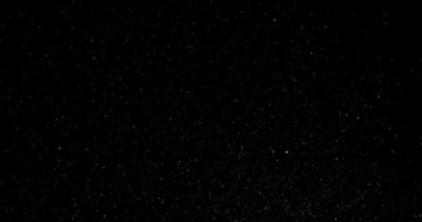 Ağır çekimde siyah arkaplanda yüzen sinematik toz parçacıkları. Atmosfer kaplaması. RED kamerayla çekildi. Yüksek kalite 4k görüntü