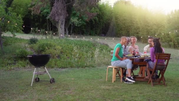 多种族朋友烧烤 夏天在院子里吃饭的人都笑了快乐的概念 高质量的4K镜头 — 图库视频影像
