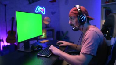 Mutlu oyuncular bilgisayar yeşili renkli neon ışıklarda çevrimiçi video oyunu oynuyorlar. Yüksek kalite 4k görüntü