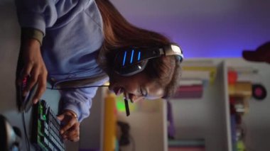 İnternette oynayan mutlu bir Latin oyuncunun gülümseyerek zaferi kutladığı dikey bir video. Yüksek kaliteli FullHD görüntüler