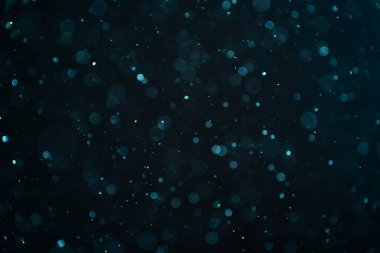 Siyah arkaplanda soyut gerçek toz parçacıkları. Parlayan ışıltılı bokeh kaplama tasarımı metin için kopyalama alanı ile. Yüksek kalite fotoğraf