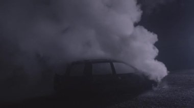 White smoke from a fire on a car rising on a black background in slow motion recorded with the RED camera. High quality 4k footage