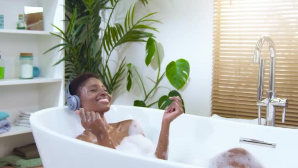 Attractive Black Woman Wearing Headphones Happy Relaxing Dancing Foam Bath — 图库视频影像