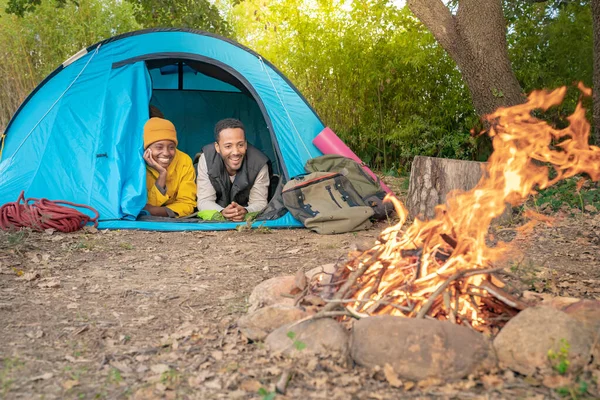 Happy couple travel and camping at natural park with tent and bonfire. Cheerful friends having fun together. Stress free relieve concept.