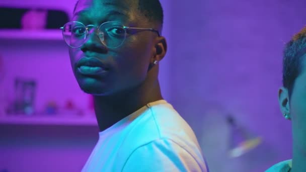 Портрет Красивого Афро Американского Молодого Человека Смотрящего Камеру Комнате Неоновым — стоковое видео