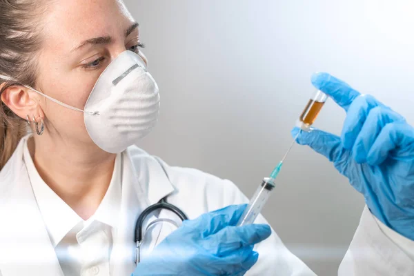 매력적 여의사가 예방용 마스크와 푸른색 장갑을 주사기를 준비하고 코로나 바이러스 — 스톡 사진