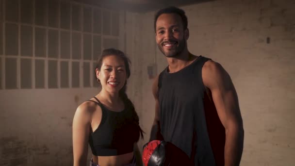 倉庫でカメラを見て笑顔若いフィットネスカップルの肖像画 ボクシングのレッスンコンセプト 高品質4K映像 — ストック動画