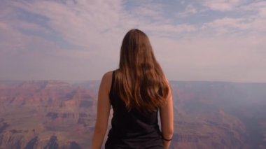 ABD 'deki Grand Canyon Ulusal Parkı' nın kenarındaki genç kadın. Yürüyüşçü mutlu ve neşeli. Özgürlük ve vahşi konsept. Yüksek kaliteli FullHD görüntüler